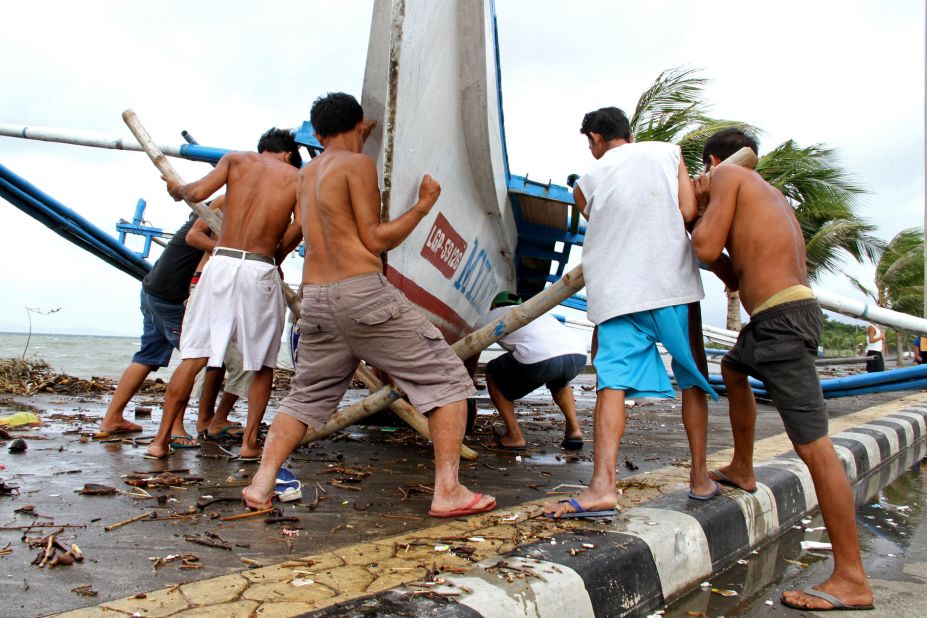 Fishermen carry their outrigger to higher ground in Legazpi on Friday, December 5. More than 600,000 people had evacuated by Saturday morning, according to the National Disaster Risk Reduction and Management Council.