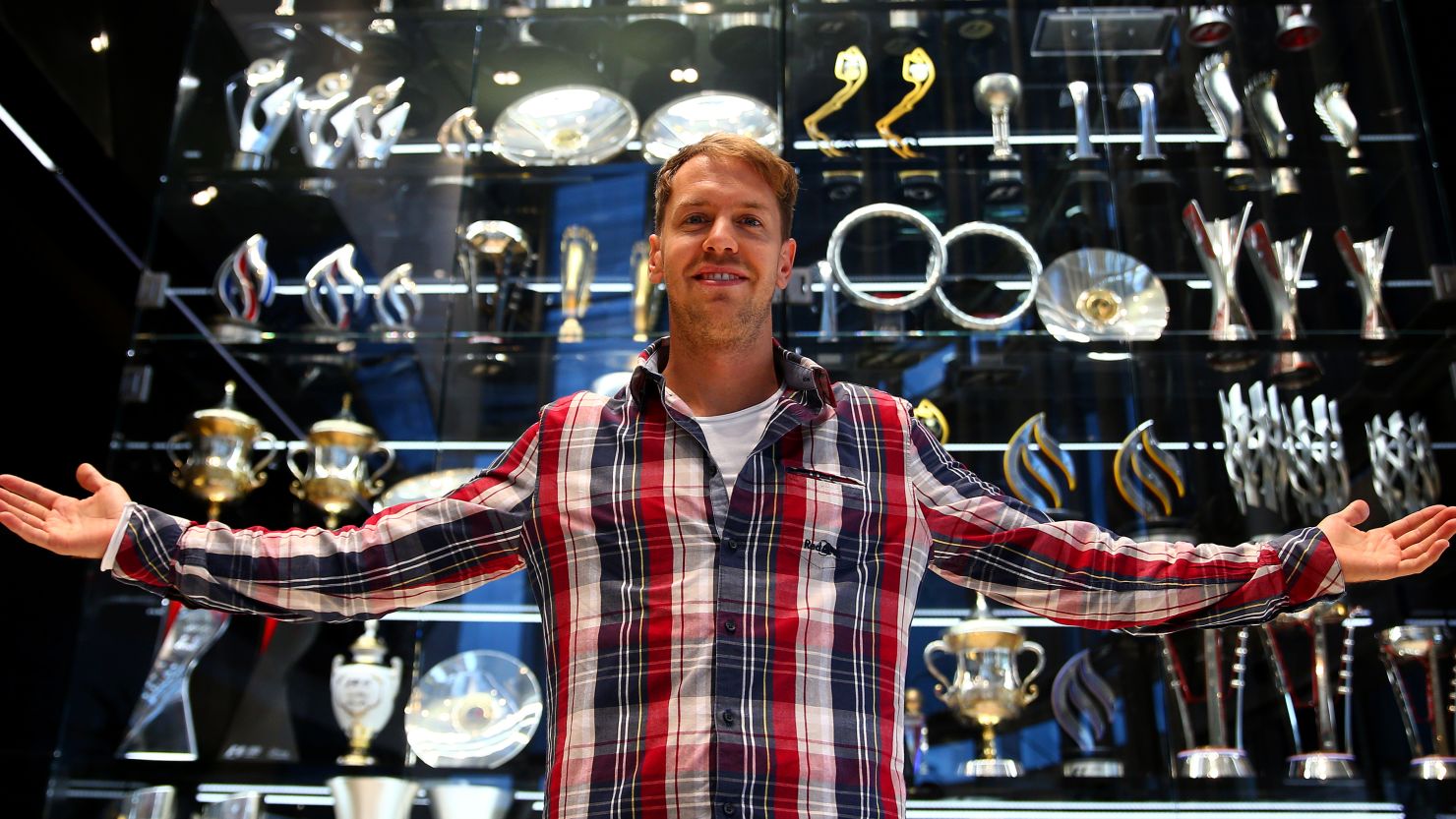 Four time world champion Sebastian Vettel stands in front of Red Bull's trophy cabinet which has been cleared out by burglars