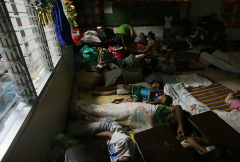Families sleep at a school used as an evacuation center on December 6 in Legazpi. 