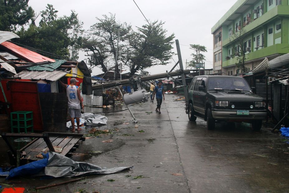 A man walks under a fallen utility pole in Tacloban, Philippines, on December 7. 