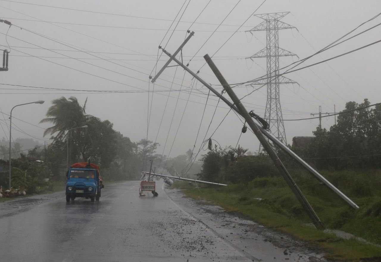 Motorists pass toppled utility poles in Camalig, Philippines, on December 7. 
