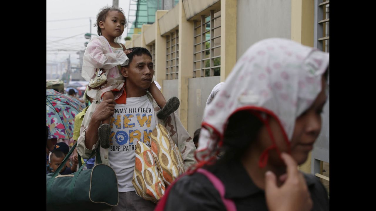 Manila residents evacuate December 8 to safer ground after the local government ordered pre-emptive evacuation in anticipation of Hagupit.