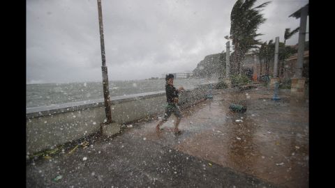 Strong winds and rain push a man around on the shore in Legazpi on December 7.