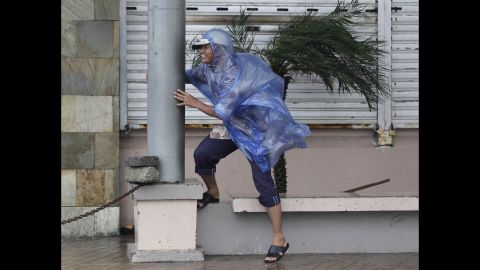 A man holds on as strong winds from Typhoon Hagupit hit Legazpi on December 7.
