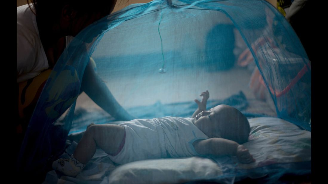 A mother watches her baby inside a mosquito net at an evacuation center in Manila on December 7.