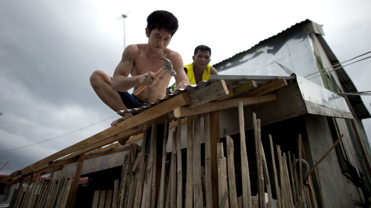 Workers reinforce the roof of a house in Manila on December 7.