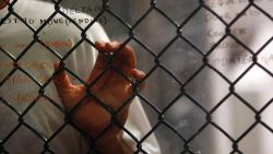 GUANTANAMO BAY, CUBA - OCTOBER 28: (EDITORS NOTE: Image has been reviewed by U.S. Military prior to transmission) A detainee stands at an interior fence at the U.S. military prison for 'enemy combatants' on October 28, 2009 in Guantanamo Bay, Cuba. Although U.S. President Barack Obama pledged in his first executive order last January to close the infamous prison within a year's time, the government has been struggling to try the accused terrorists and to transfer them out ahead of the deadline. Military officials at the prison point to improved living standards and state of the art medical treatment available to detainees, but the facility's international reputation remains tied to the 'enhanced interrogation techniques' such as waterboarding employed under the Bush administration. (Photo by John Moore/Getty Images)