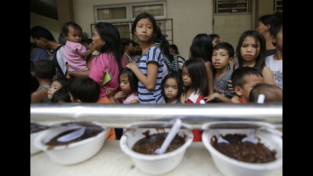 Evacuees line up for food at an evacuation center in Manila on December 8.