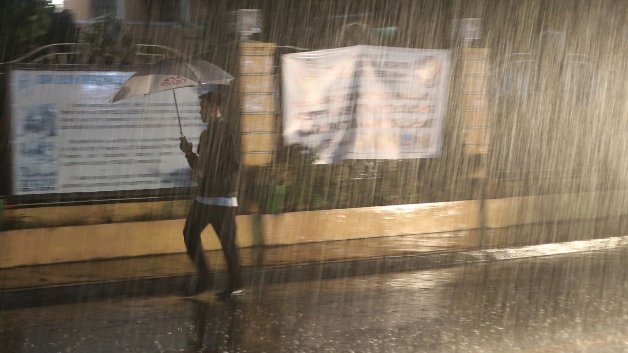 A man walks through heavy rain in San Juan, Philippines, on December 8.