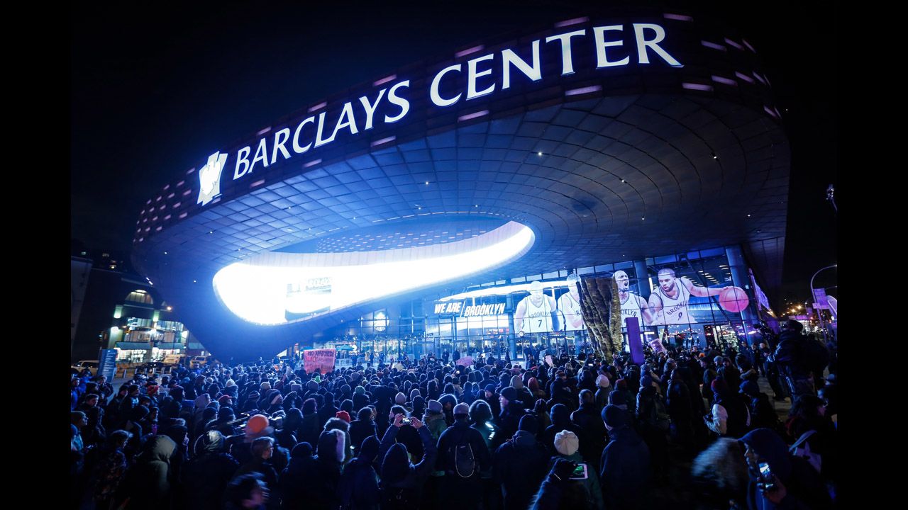 Protesters gather in front of the Barclays Center during an NBA game in New York on Monday, December 8.