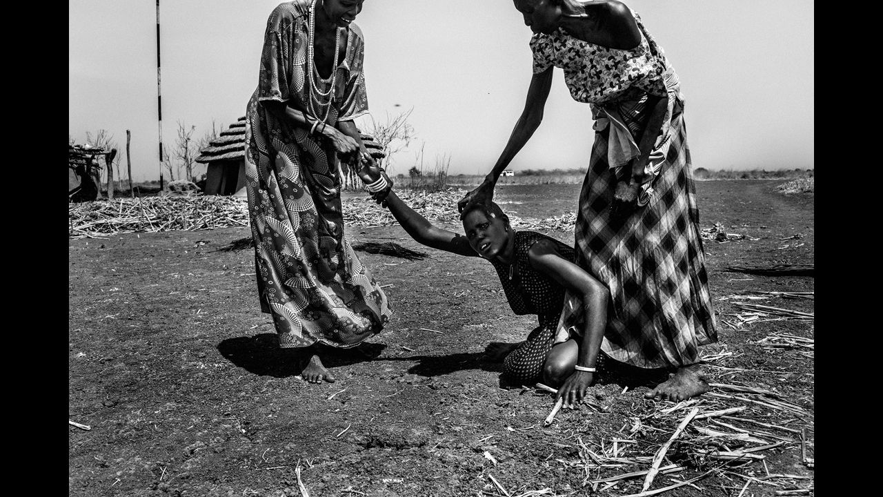 Women grieve the loss of their home near Mingkaman. The conflict has wiped out entire neighborhoods and transformed into a full-blown war between the Nuer and the Dinka. Machar belongs to the Nuer community, while the President is a Dinka.