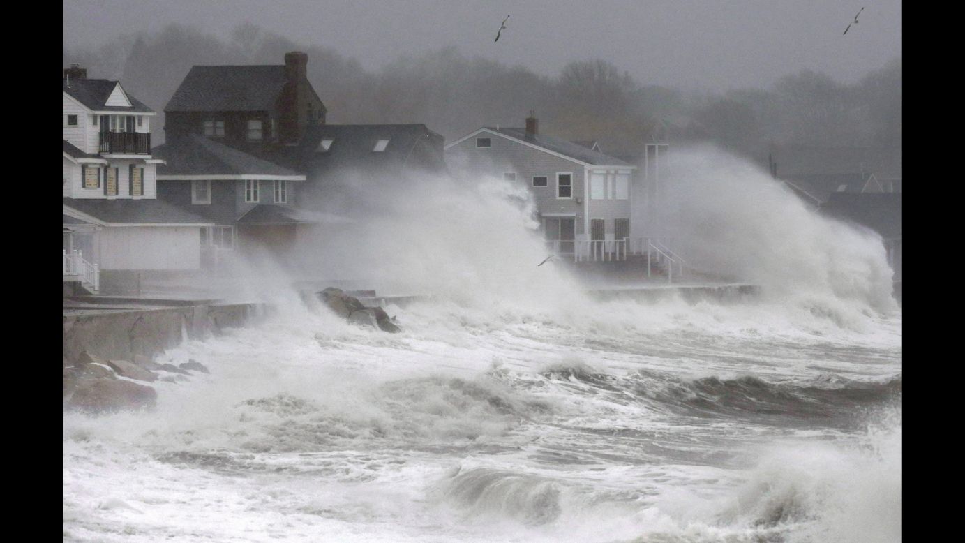 Waves splash against a seawall and onto houses in Scituate, Massachusetts, on December 9.