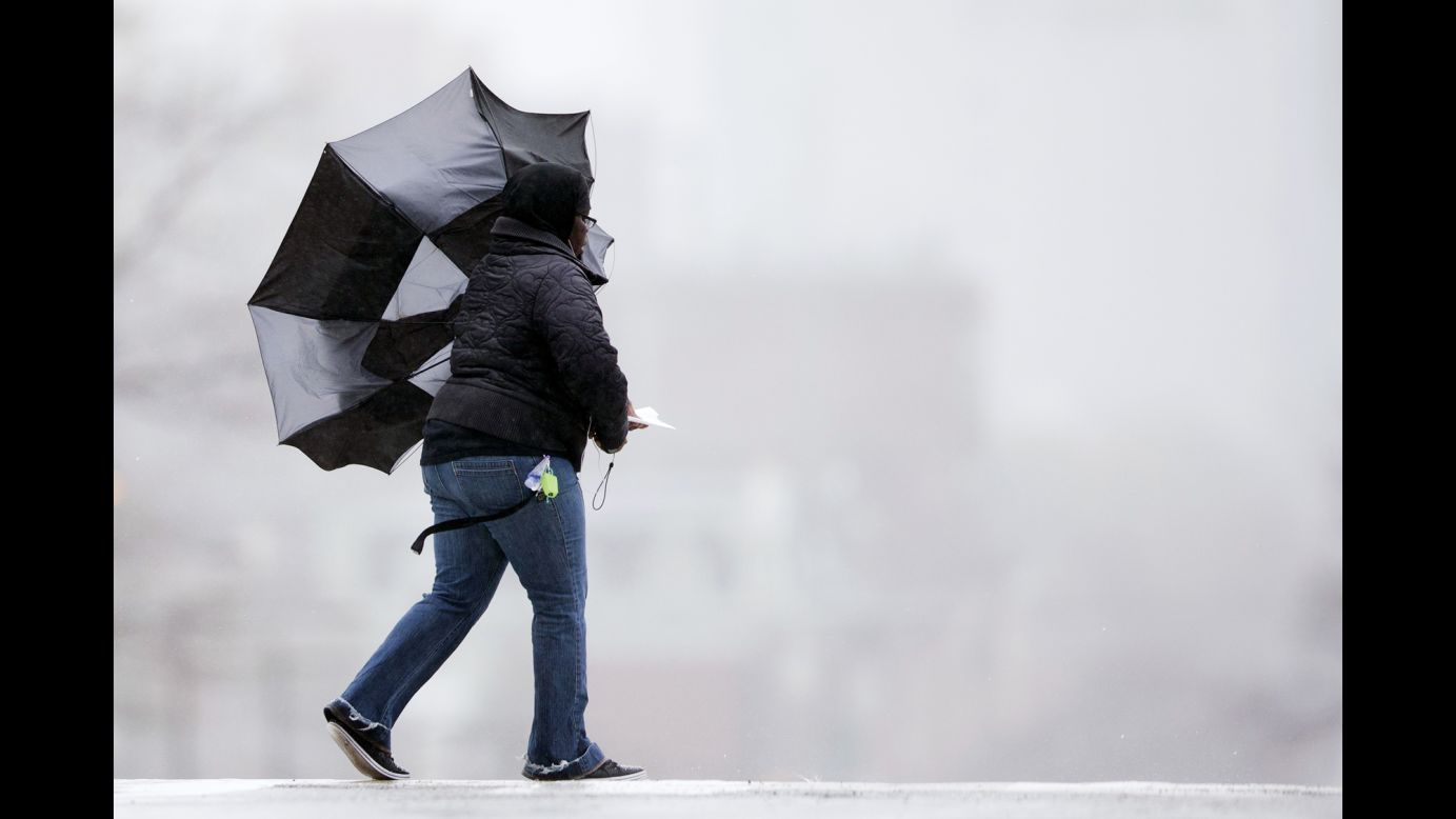 A woman's umbrella is blown back by winds in Philadelphia on December 9.