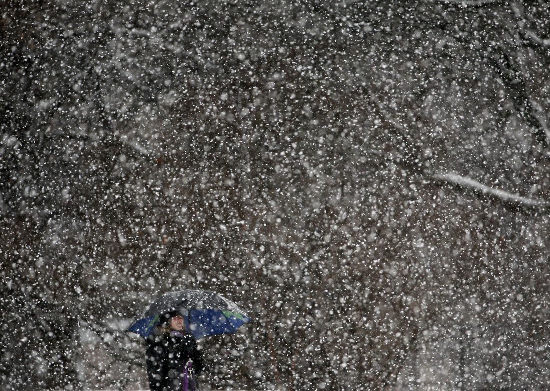 A woman walks through snow in a park in Albany, New York, on Wednesday, December 10. 