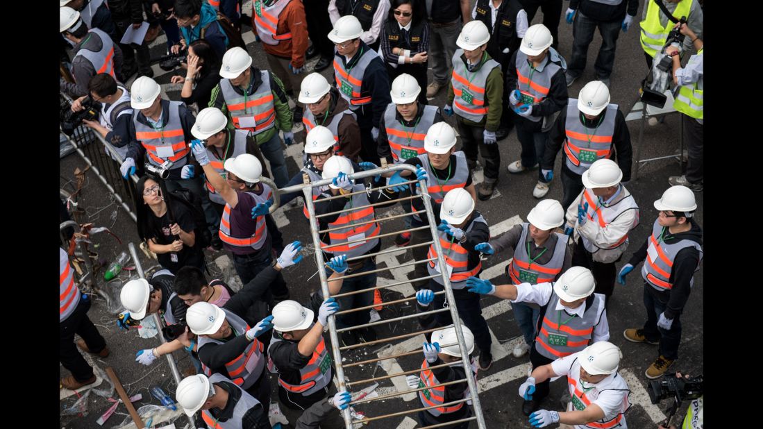 Authorities dismantle a barricade December 11 at the main protest site.