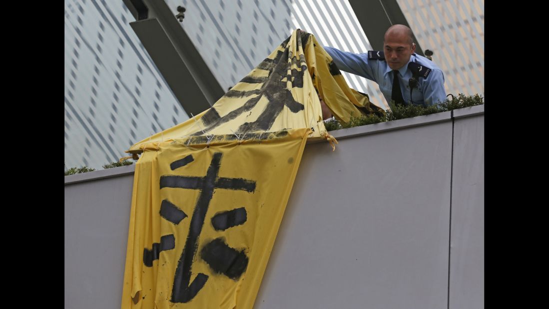 A police officer removes a protest banner from a bridge December 11.