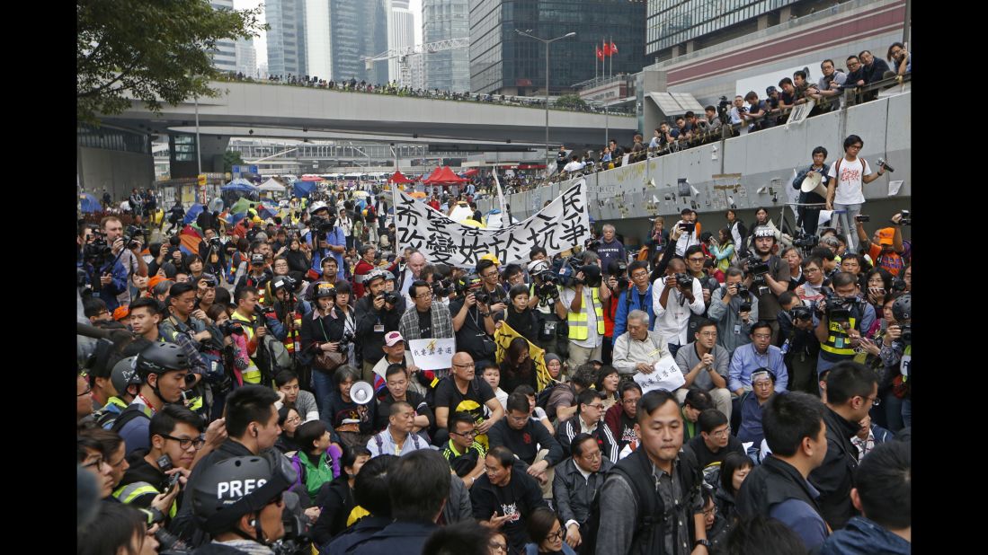 Protesters attend a sit-in rally as police officers break down the campsite.