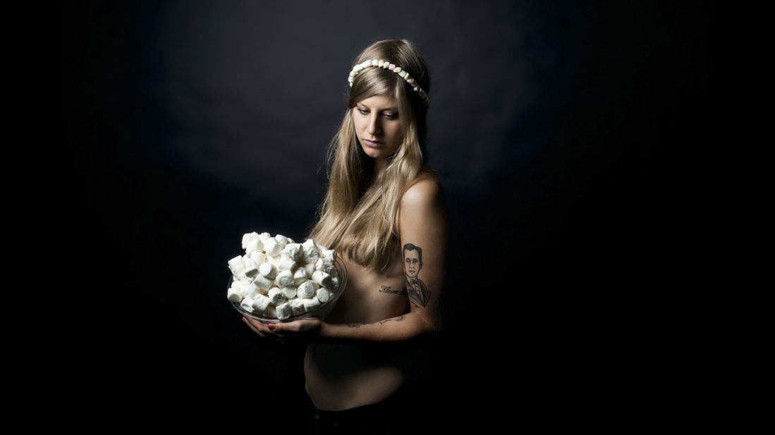 A model poses with marshmallows. The models are friends of Ruetten's, usually with tattoos and piercings. "It underlines the concept that they are 'children of the modern age,' having been brought up in the changing America, often defined by the culture of fast food," Ruetten said.