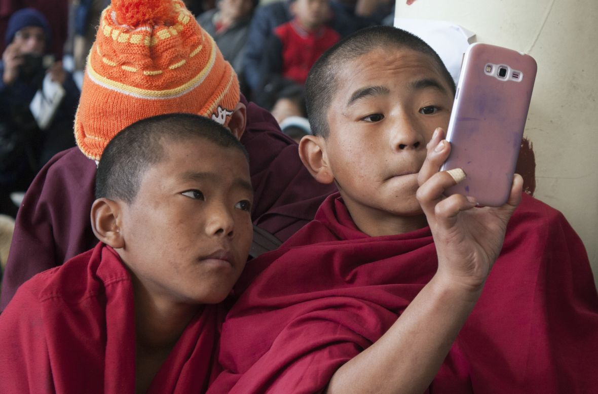DECEMBER 11 - DHARAMSALA, INDIA: A novice exiled Tibetan Buddhist monk uses his mobile phone camera as people gather at the Tsuglakhang temple to mark the 25th anniversary of their spiritual leader, the Dalai Lama, receiving the Nobel Peace Prize. The Tibetan leader was awarded the prize in 1989 for his commitment to non-violence. 