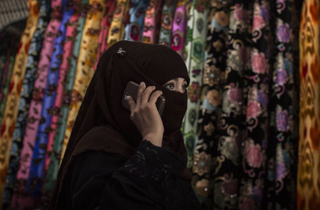 A Uyghur woman wears a veil as she shops at a local market on August 2, 2014 in Kashgar, Xinjiang.