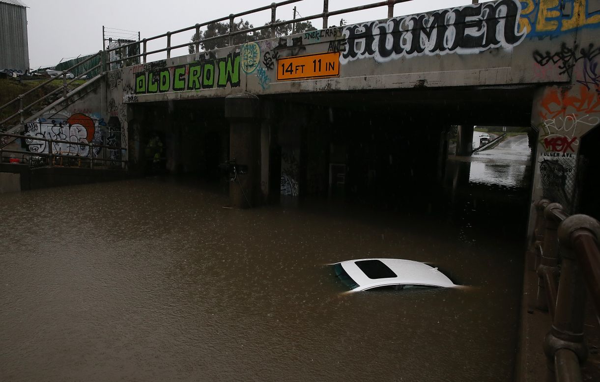 Only the roof of a car is left visible as it sits underwater in a flooded section of Ashby Avenue on December 11 in Berkeley, California.