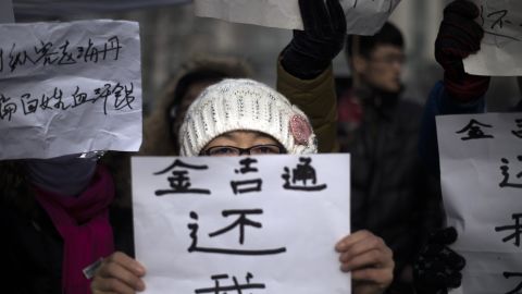 A woman holds up a sign reading "we are not paid" in a protest over corruption and unpaid wages in Langfang this week.