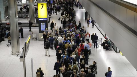 People queue in the luggage hall of Terminal 5 at Heathrow Airport in London, Friday, Dec. 12, 2014.