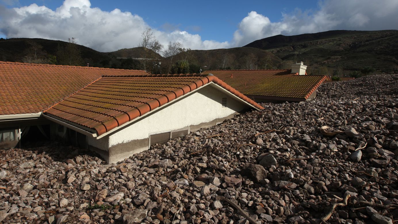 Homes are covered with rocks and mud after debris flows smashed into houses on December 12, in Camarilla, California.