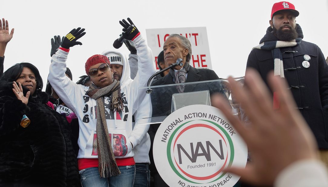 From left, Samaira Rice, the mother of Tamir Rice; Lesley McSpadden, the mother of Michael Brown Jr.; the Rev. Al Sharpton and Michael Brown Sr., the father of Michael Brown Jr, raise their hands in the air during the "Justice For All" march and rally through Washington on December 13. 