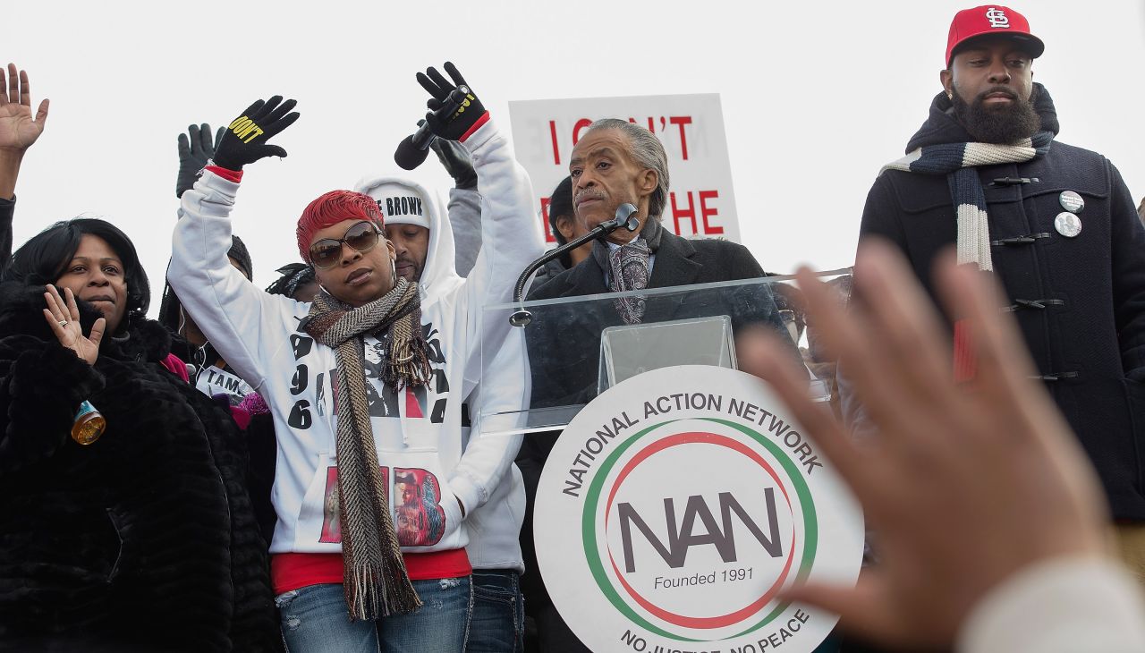 From left, Samaira Rice, the mother of Tamir Rice; Lesley McSpadden, the mother of Michael Brown Jr.; the Rev. Al Sharpton and Michael Brown Sr., the father of Michael Brown Jr, raise their hands in the air during the "Justice For All" march and rally through Washington on December 13.