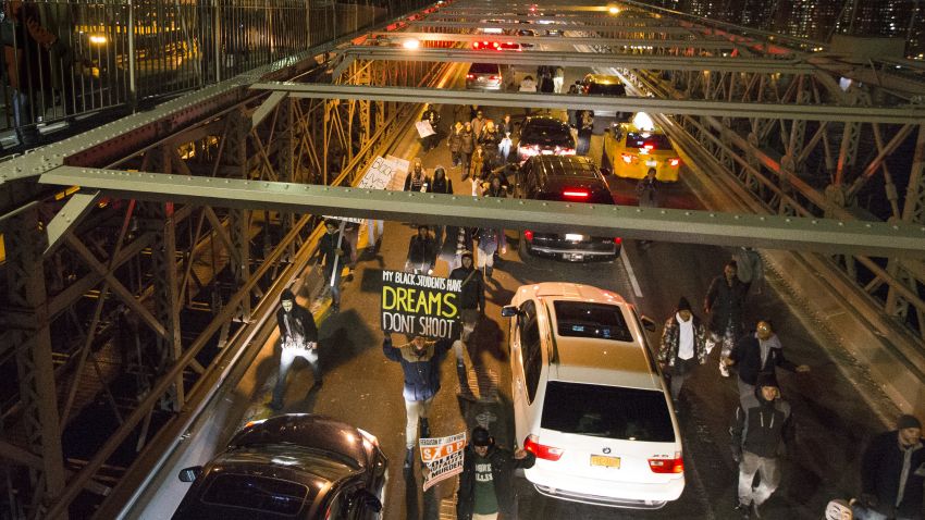 Demonstrators march over the inbound lane of the Brooklyn Bridge in New York, Saturday, December 13. 