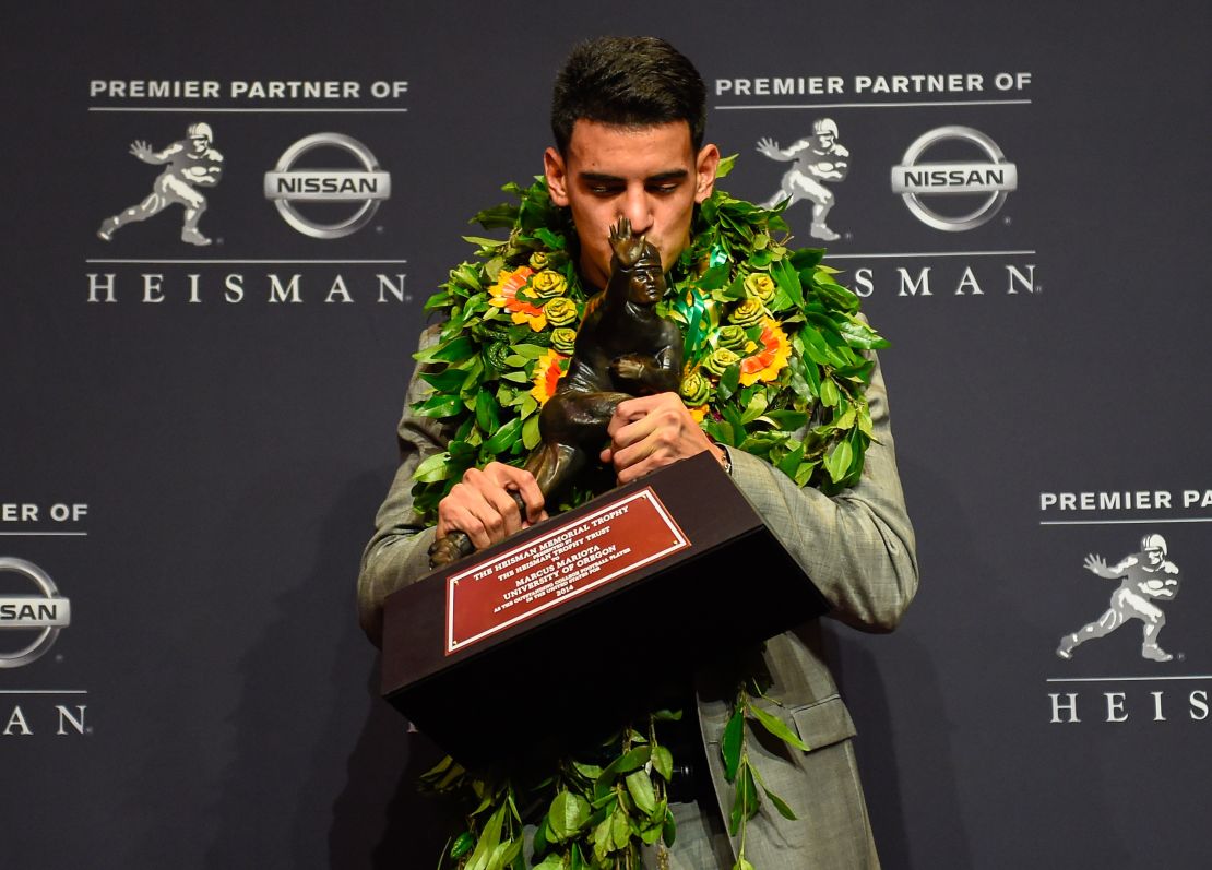 Marcus Mariota kisses the Heisman Trophy after he was named college football's best player.