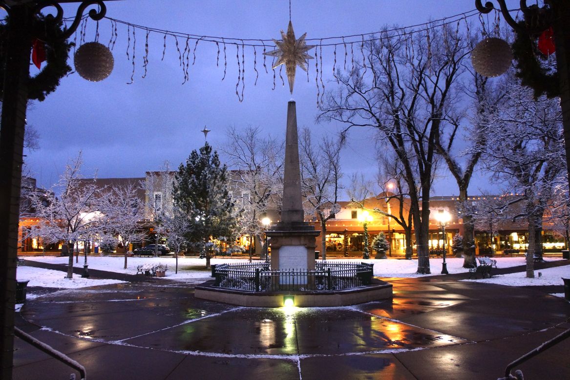 The plaza in Santa Fe, New Mexico, is blanketed with snow on Sunday, December 14, following snow showers from a storm system that slammed California and moved into the area.  A powerful storm that has been lashing Northern California has moved southward as weather systems<a href="http://www.cnn.com/2014/12/10/us/weather/index.html" target="_blank"> whip rain and snow</a> at the West Coast and inland areas.