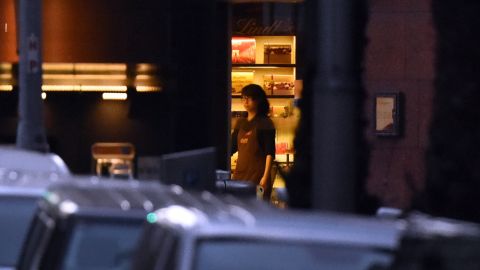 A hostage stands by the front entrance of the cafe as she turns off the lights on Monday, December 15.