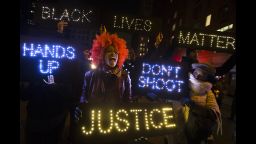 A demonstrator chants during a rally in downtown Manhattan in New York, Saturday, Dec. 13, 2014, during the Justice for All rally and march. In the past three weeks, grand juries have decided not to indict officers in the chokehold death of Eric Garner in New York and the fatal shooting of Michael Brown in Ferguson, Mo. The decisions have unleashed demonstrations and questions about police conduct and whether local prosecutors are the best choice for investigating police. (AP Photo/John Minchillo)