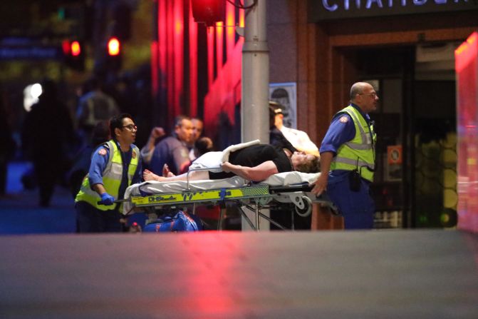 An injured hostage is wheeled to an ambulance after shots were fired during the raid on the cafe.