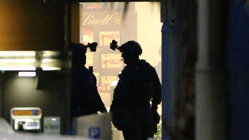 Two armed police officers stand ready to enter the cafe on December 16.