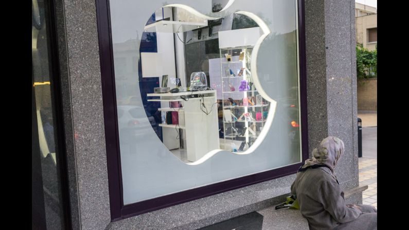 A local sits in front of an unofficial Apple reseller in Isfahan.