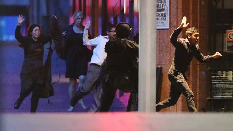 Hostages run toward police officers on December 16.