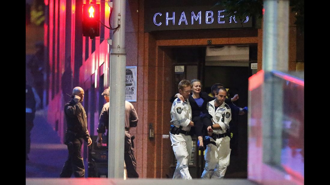 An injured hostage is carried to an ambulance from a cafe in Sydney on December 16. Gunfire erupted early Tuesday as police stormed the Lindt Chocolate Cafe, where a gunman had been holding hostages since Monday morning.