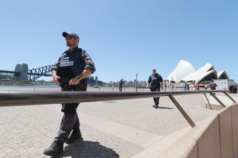 Armed police patrol near the Sydney Opera House. Major landmarks in Sydney were evacuated as police responded to the hostage situation.