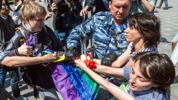 Caption:A man (L) takes away a rainbow flag as a policeman detain gay rights activists during their protest in central Moscow on May 31, 2014. Riot police on May 31 arrested two women as a small group of gay rights activists tried to stage a rally in central Moscow dedicated to Conchita Wurst, the bearded Austrian transvestite who won this year's Eurovision song contest. AFP PHOTO / DMITRY SEREBRYAKOV (Photo credit should read DMITRY SEREBRYAKOV/AFP/Getty Images)