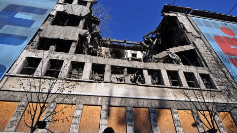 A woman walks on March 22, 2014 in front of the building of the former federal Interior Ministry in Belgrade, which was destroyed during the 1999 NATO air campaign against Serbia and Montenegro.
