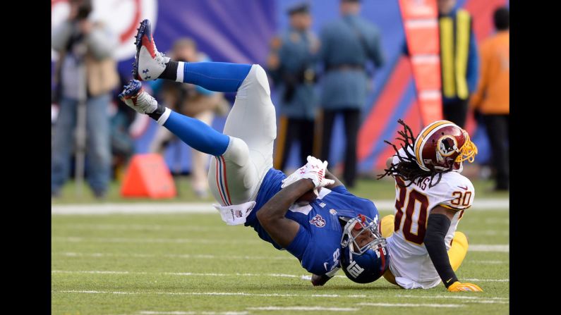 New York Giants tight end Larry Donnell, left, is upended by Washington safety E.J. Biggers during an NFL game played Sunday, December 14, in East Rutherford, New Jersey.