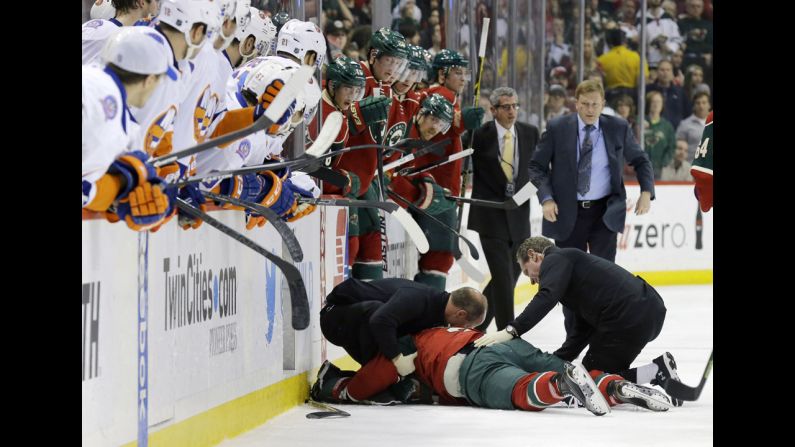 Medical personnel tend to Minnesota Wild defenseman Keith Ballard after he was checked into the boards during an NHL hockey game Tuesday, December 9, in St. Paul, Minnesota. Ballard suffered a concussion and facial fractures on the hit, which was delivered by Matt Martin of the New York Islanders.
