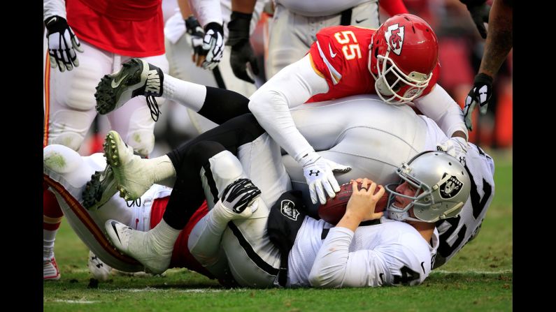 Oakland Raiders quarterback Derek Carr is sacked by Kansas City's Tamba Hali, bottom left, during the Chiefs' 31-13 home victory on Sunday, December 14.