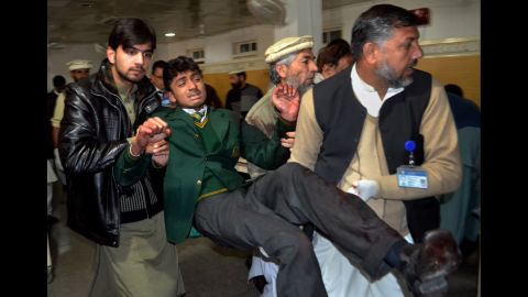 Volunteers carry a student at a hospital in Peshawar.