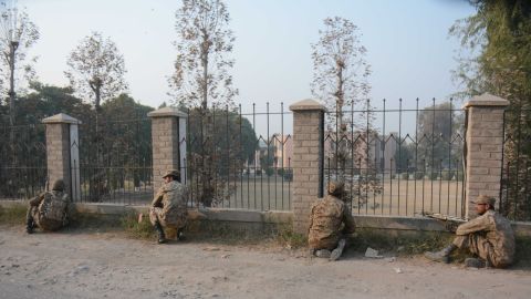 Pakistani soldiers position themselves at a fence near the besieged school.