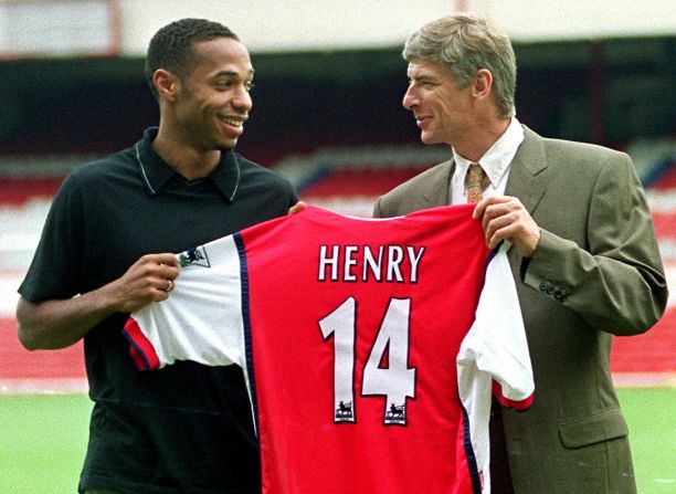After a year with Juventus, Henry's career took off when he signed for English side Arsenal in 1999. Here, he holds his newly pressed shirt with Arsenal manager Arsene Wenger at the North London club's old ground, Highbury.  