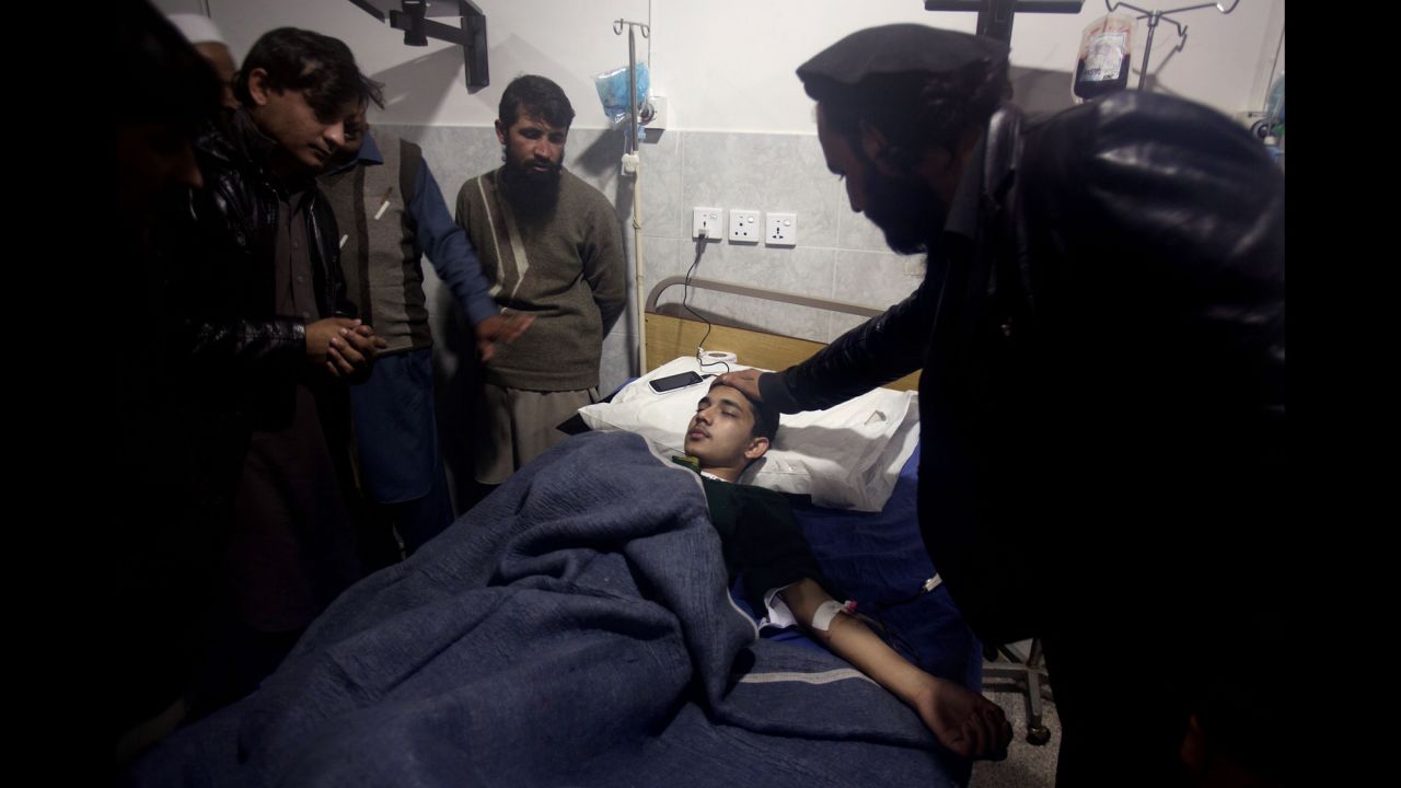 A man comforts a student who survived the attack.